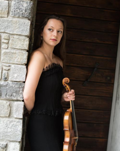 		Person leaning against a wall, holding a violin
	
